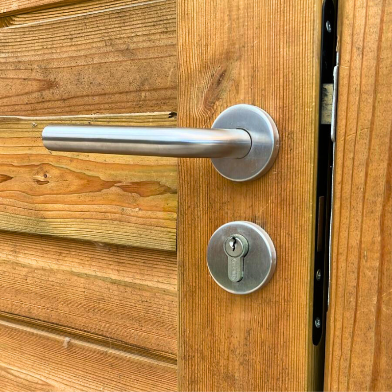 Détail de la poignée en métal et de la serrure à cylindre pour porte d'abri de jardin en bois
