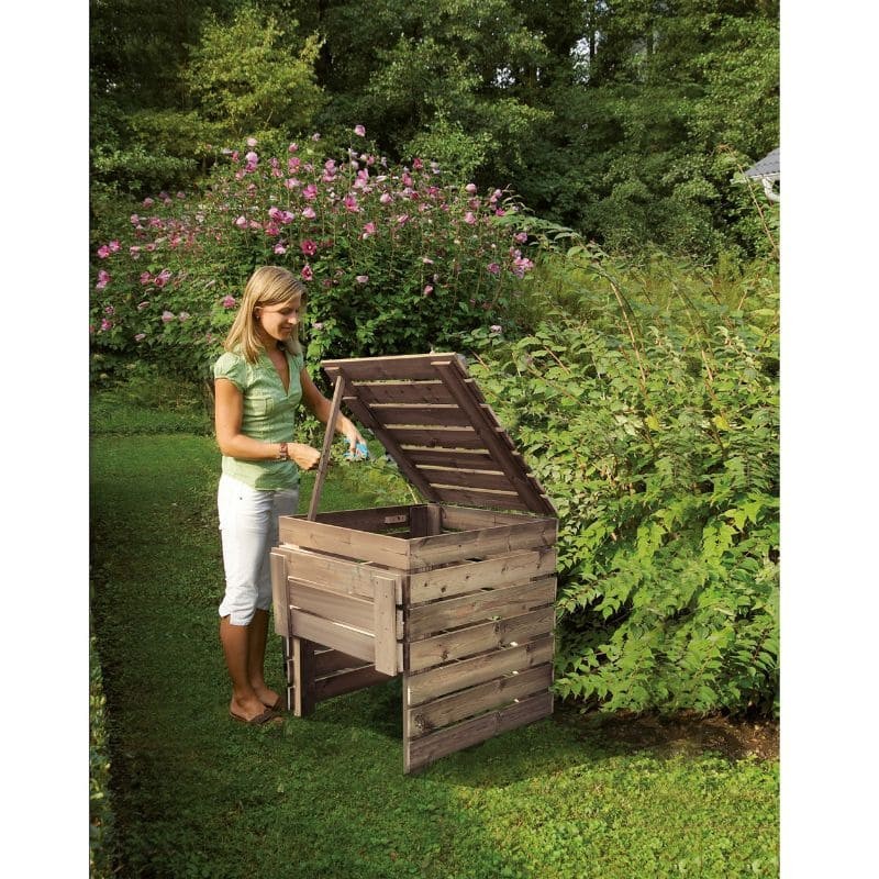 femme utilisant un bac à compost en bois dans son jardin