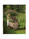 femme utilisant un bac à compost en bois dans son jardin