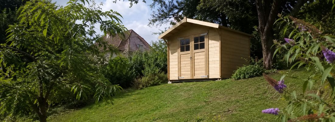 abri de jardin en bois installé sur un terrain en pente